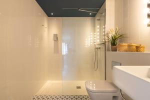 uma casa de banho com um chuveiro, um WC e um lavatório. em Port Plaza Apartments em Tarragona