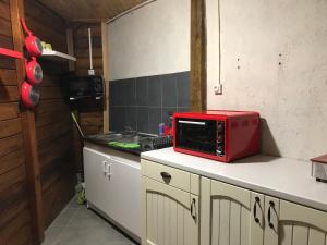 un forno a microonde rosso seduto su un bancone in cucina di Chambre2 Résidence Beauregard a Koungou