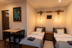 um quarto com 2 camas individuais e uma mesa em Domek u Basi em Muszyna
