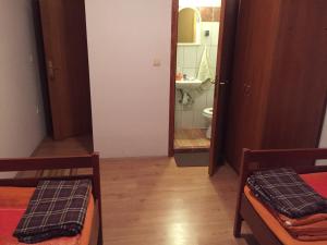 a room with two beds and a bathroom with a mirror at Sobe Matea - prenoćište in Vinkovci