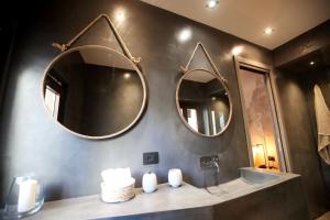 a bathroom with two mirrors and a sink at Casa Nostra Boutique Hotel & Spa in Palermo