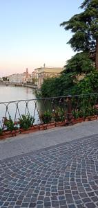 a fence next to a body of water with flowers at Adria Bella LT Z00157 in Adria