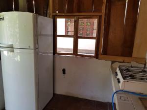 uma cozinha com um frigorífico branco e uma janela em Rancho villas de alicia em La Paz