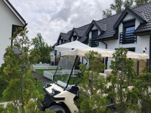 a golf cart parked in front of a house at Domki Apartamenty Akacja in Sianozety