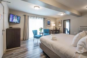 a hotel room with a bed and a tv at Kent Inn in Lindsay