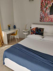 ein Schlafzimmer mit einem Bett und einem Schreibtisch mit einem Stuhl in der Unterkunft Dimora Dei Cento in Pescara