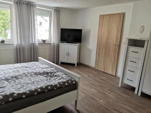 una camera con letto, televisore e cassettiera di Schönes Ferienhaus im Herzen von Quentel a Lichtenau