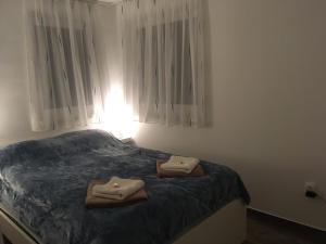 a bedroom with a bed with two towels on it at Tisza Dream Apartman in Tiszakécske