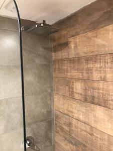 a bathroom with a shower with a stone wall at Bariloche View Apartment in San Carlos de Bariloche +19 photos