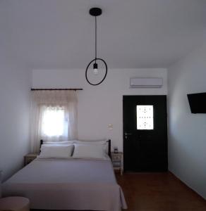 a bedroom with a bed and a window and a lamp at STUDIO OASIS in Kokkíni Khánion