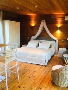 a bedroom with a white bed and a wooden ceiling at Le Mas du Pourret in Pierrefeu-du-Var