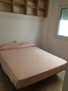 een bed in een kleine kamer met bij alojamiento vistas al mar in Cartagena