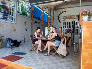 un grupo de personas sentadas en una mesa en un restaurante en Binh An Backpacker Guesthouse, en Ho Coc