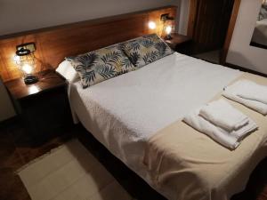 a bedroom with a white bed with two lamps at LA ALDEA in Llanes