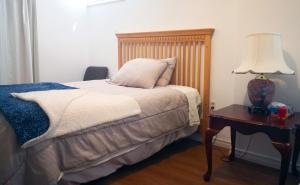 a bedroom with a bed and a table with a lamp at GA STAY in Oakville