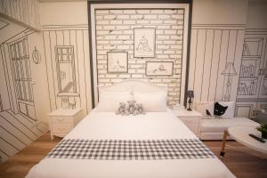 a bedroom with a white bed and a brick wall at Salmon B&B in Hualien City