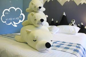 two teddy bears sitting on top of a bed at Salmon B&B in Hualien City
