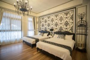 a bedroom with two beds and a chandelier at Salmon B&B in Hualien City