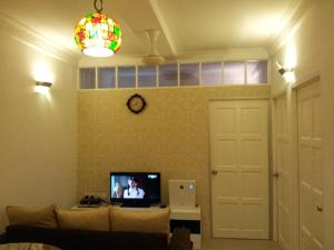 sala de estar con sofá y TV en Fastbook Bendera Home 8 & 10pax, en Ayer Itam