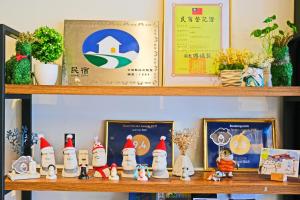 a shelf with gnomes and pictures on it at Salmon B&B in Hualien City