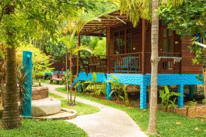 une maison avec une table bleue et des chaises devant elle dans l'établissement Baan Kiao, à Haad Yao