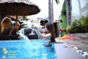 a young woman in a swimming pool with water splashing at Mi Lan Boutique Resort in Vung Tau