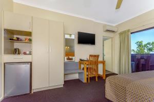 a room with a table, chairs, and a television at Quality Hotel Darwin Airport in Darwin