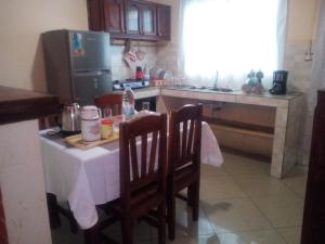 a kitchen with a table and two chairs and a refrigerator at IVATO Airport STUDIOS CHAMBRES in Ivato