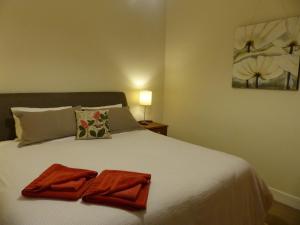 1 dormitorio con 1 cama con 2 toallas en Andy's Accommodation, en Peterborough