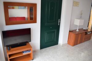 uma sala de estar com uma porta verde e uma televisão em San Fernando Palace AT711 em Oliva