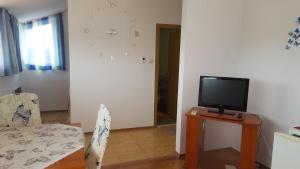 a living room with a tv and a table with a chair at Beautiful Penthouse Apartment in Sunny Beach