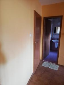 a bathroom with a door leading to a toilet at Hristovi Apartments & Studios in Pomorie