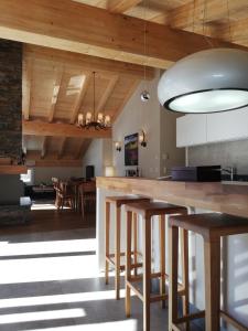 a kitchen with wooden ceilings and a bar with stools at Pure Hinterthal in Maria Alm am Steinernen Meer
