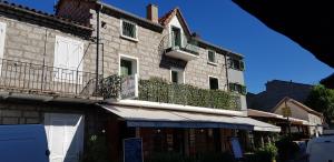 a building with two balconies on the side of it at Hôtel Restaurant L'Aiglon in Zonza