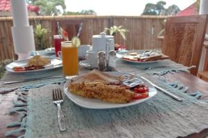 a table with a plate of food on a table at Shrining Cottages Lembongan in Nusa Lembongan