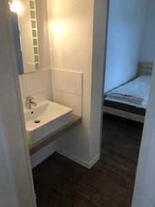 a bathroom with a sink and a mirror and a bed at Mühlweg-Appartment in Alzenau in Unterfranken