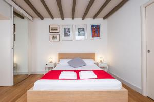 a white bedroom with a large bed with red blanket at Casa Di Armando al Pantheon in Rome