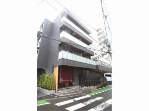 a black building on a street with a crosswalk at Apartment Hotel Tenjin TUMUGU in Fukuoka