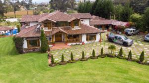 a house with a car parked in front of it at Casa d'Campo Tababela Hotel Boutique in Tababela