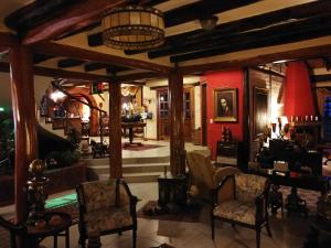 塔巴貝拉的住宿－卡薩德坎波塔巴貝拉精品酒店，客厅配有椅子、桌子和红色墙壁