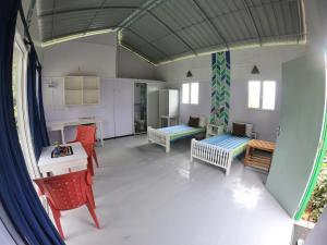 a living room with tables and chairs and a kitchen at Anne's Maisonnette in Galle