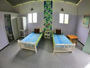 an empty room with two beds and a table at Anne's Maisonnette in Galle
