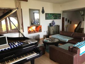 sala de estar con piano y sofá en Villa Eden Park sur la plage, en Fnidek