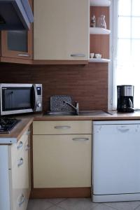 a kitchen with a microwave and a stove top oven at L'écoutille in Dieppe