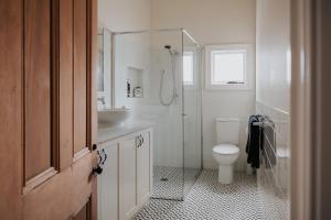 a bathroom with a shower and a toilet and a sink at Apartments on Belmore -The Ferguson in Yarrawonga