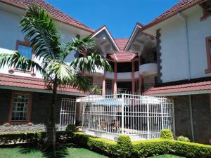 a house with a white gate in front of it at Villa Leone Boutique Hotel in Nairobi