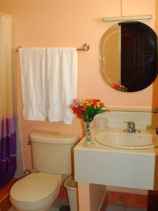a bathroom with a toilet and a sink and a mirror at Playa Papagayo Beach Inn in Olongapo