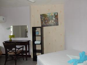 a bedroom with a bed and a desk and a mirror at Oslob Seafari Resort in Oslob