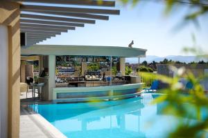 a swimming pool with a bar on a building at Angelo Del'Arte Estate in Corfu Town