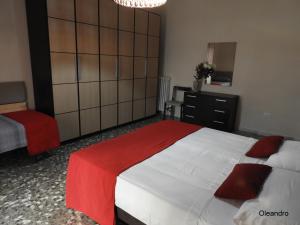1 dormitorio con 1 cama grande con manta roja en Oleandro e Glicine, en Lecce